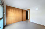 Discover the elegance of this well-lit room featuring a large wooden wardrobe, offering ample storage space.