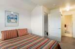 This cozy bedroom features a comfortable bed with colorful striped bedding and pillows, perfect for a relaxing retreat.
