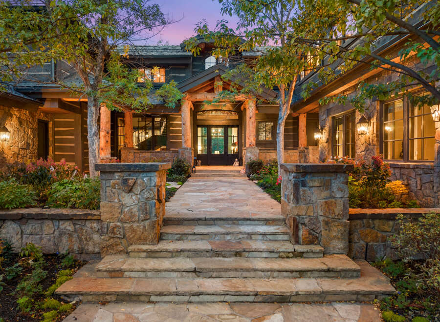 This stunning property boasts a grand entrance with a stone pathway leading to the front door.