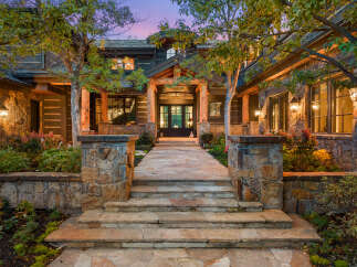 This stunning property boasts a grand entrance with a stone pathway leading to the front door.