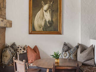 This charming dining area features a round wooden table, perfect for intimate gatherings.