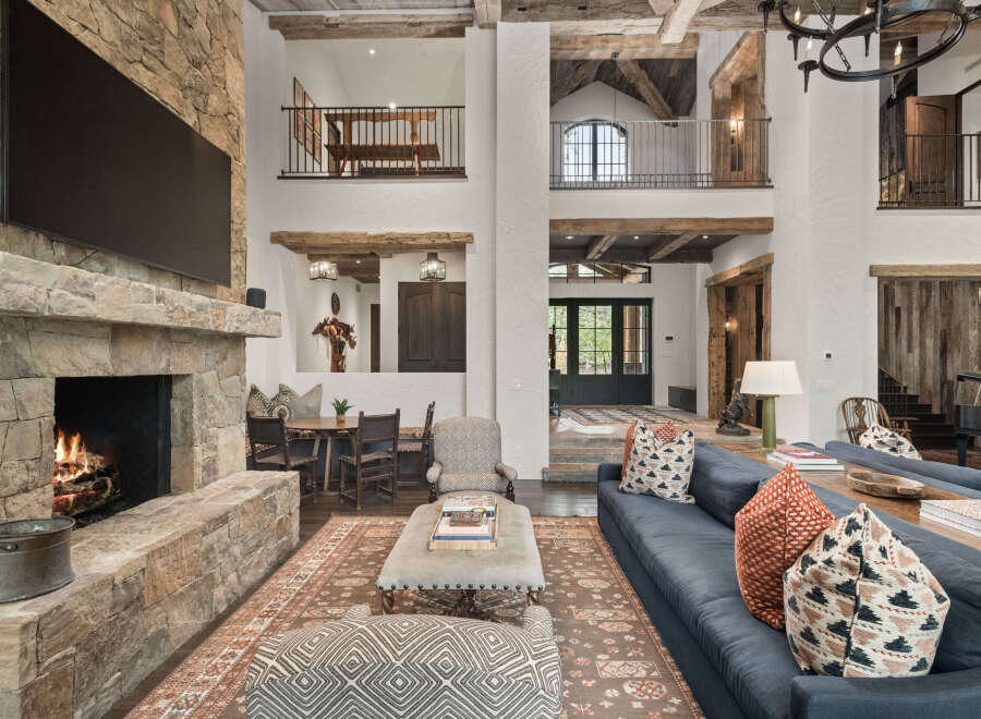 This stunning property boasts a grand living space with a stone fireplace, creating a warm and inviting atmosphere.