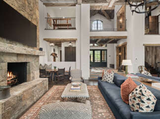 This stunning property boasts a grand living space with a stone fireplace, creating a warm and inviting atmosphere.