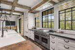 This stunning kitchen boasts a luxurious design with exposed wooden beams and a modern Wolf range.