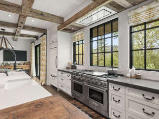 This stunning kitchen boasts a luxurious design with exposed wooden beams and a modern Wolf range.