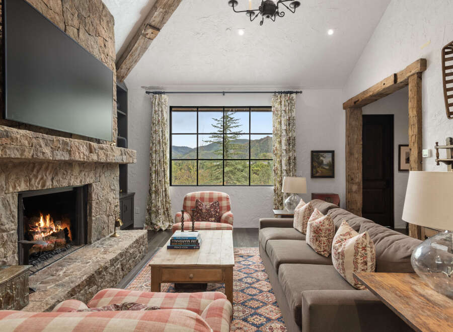 Experience the warmth and charm of this stunning living room, featuring a cozy fireplace and a large flat-screen TV.