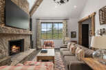 Experience the warmth and charm of this stunning living room, featuring a cozy fireplace and a large flat-screen TV.