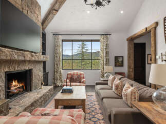 Experience the warmth and charm of this stunning living room, featuring a cozy fireplace and a large flat-screen TV.