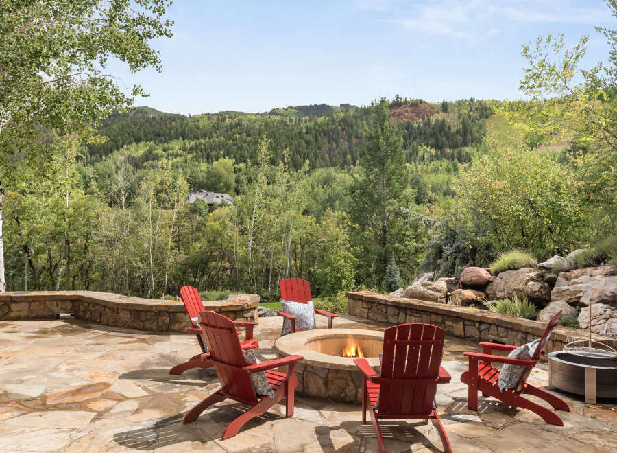 Enjoy the ultimate outdoor living experience with this stunning property, featuring a cozy fire pit surrounded by comfortable seating.
