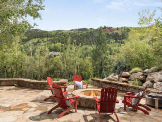 Enjoy the ultimate outdoor living experience with this stunning property, featuring a cozy fire pit surrounded by comfortable seating.