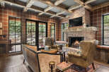 This stunning living room boasts a cozy ambiance with its brick fireplace, perfect for those chilly evenings.