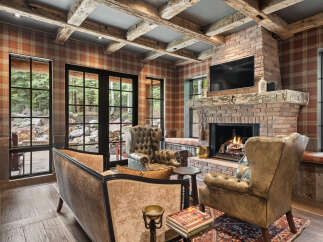 This stunning living room boasts a cozy ambiance with its brick fireplace, perfect for those chilly evenings.