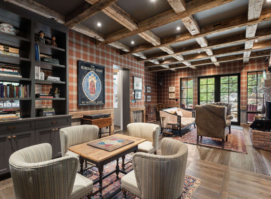 Step into a world of rustic elegance with this stunning living space, featuring exposed wooden beams and a cozy brick fireplace.