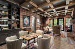 Step into a world of rustic elegance with this stunning living space, featuring exposed wooden beams and a cozy brick fireplace.