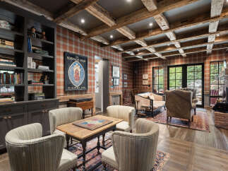 Step into a world of rustic elegance with this stunning living space, featuring exposed wooden beams and a cozy brick fireplace.