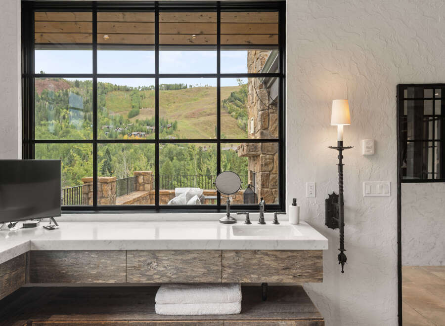 Experience luxury living with this stunning bathroom featuring a breathtaking mountain view.