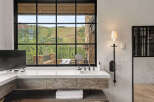Experience luxury living with this stunning bathroom featuring a breathtaking mountain view.