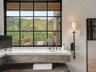 Experience luxury living with this stunning bathroom featuring a breathtaking mountain view.