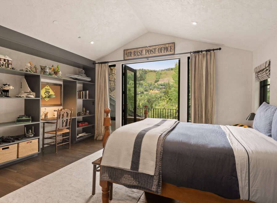 This stunning bedroom offers a serene retreat with its vaulted ceiling and expansive views.