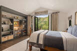 This stunning bedroom offers a serene retreat with its vaulted ceiling and expansive views.