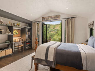 This stunning bedroom offers a serene retreat with its vaulted ceiling and expansive views.