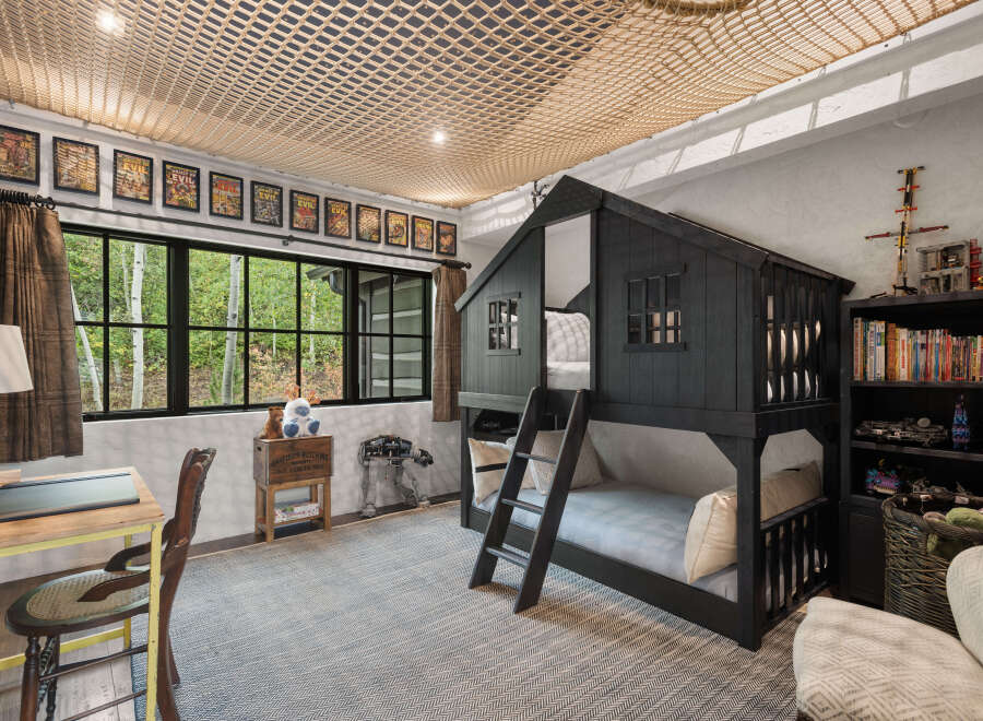 This charming bedroom features a unique bunk bed designed to resemble a house, perfect for a child's imaginative play.