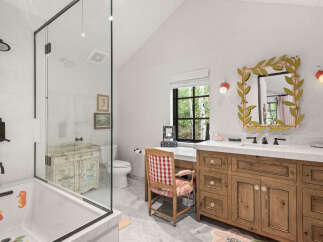 This charming bathroom features a unique blend of rustic and elegant design elements.