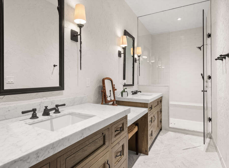 Step into luxury with this stunning bathroom featuring a sleek marble countertop and elegant dark fixtures.
