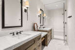 Step into luxury with this stunning bathroom featuring a sleek marble countertop and elegant dark fixtures.