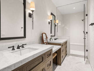 Step into luxury with this stunning bathroom featuring a sleek marble countertop and elegant dark fixtures.