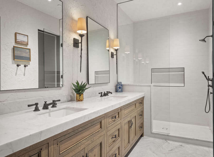 This luxurious bathroom features a stunning marble countertop and a custom wooden vanity, creating a spa-like atmosphere.