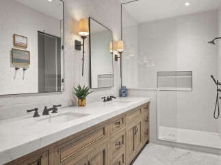 This luxurious bathroom features a stunning marble countertop and a custom wooden vanity, creating a spa-like atmosphere.