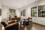 This luxurious home office boasts a sophisticated design with rich wooden accents and comfortable leather seating.