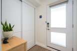 Step into this inviting entryway, showcasing a modern design with sleek white doors and a stylish wooden console.
