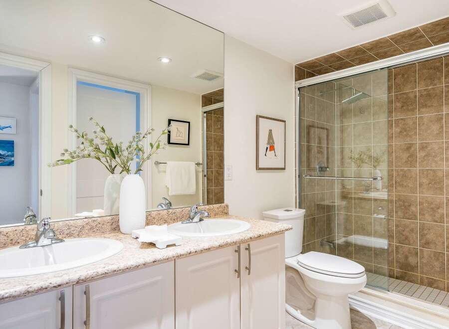 This stunning bathroom features a modern design with a spacious shower and elegant vanity.