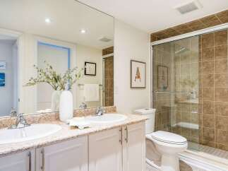 This stunning bathroom features a modern design with a spacious shower and elegant vanity.