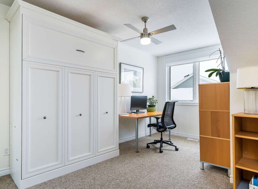 This stylish home office features a built-in white cabinet, providing ample storage space.