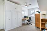 This stylish home office features a built-in white cabinet, providing ample storage space.