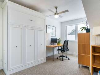 This stylish home office features a built-in white cabinet, providing ample storage space.
