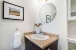 This stunning bathroom features a modern design with a sleek vanity and a stylish round mirror.