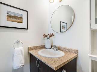 This stunning bathroom features a modern design with a sleek vanity and a stylish round mirror.