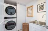 This modern laundry room features a sleek, stacked LG washer and dryer, maximizing space and efficiency.