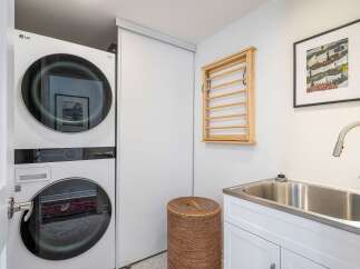 This modern laundry room features a sleek, stacked LG washer and dryer, maximizing space and efficiency.