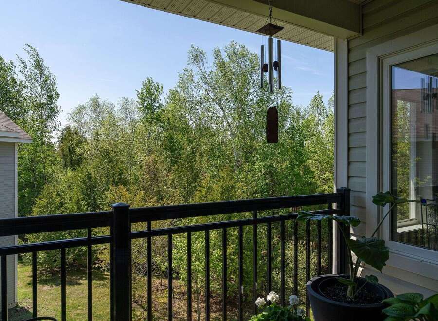Enjoy serene views from this charming balcony overlooking lush greenery.