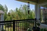 Enjoy serene views from this charming balcony overlooking lush greenery.