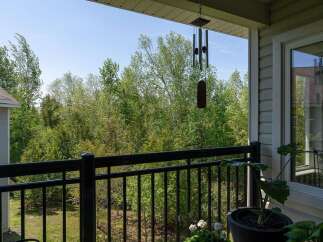 Enjoy serene views from this charming balcony overlooking lush greenery.