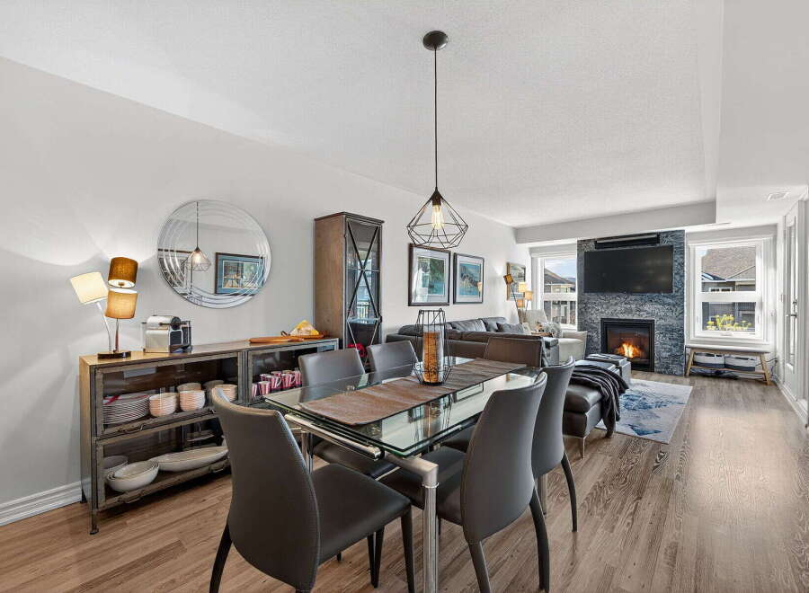 Step into luxury with this stunning property, featuring a modern dining area with a glass table and sleek chairs.