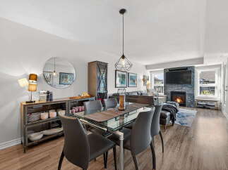 Step into luxury with this stunning property, featuring a modern dining area with a glass table and sleek chairs.