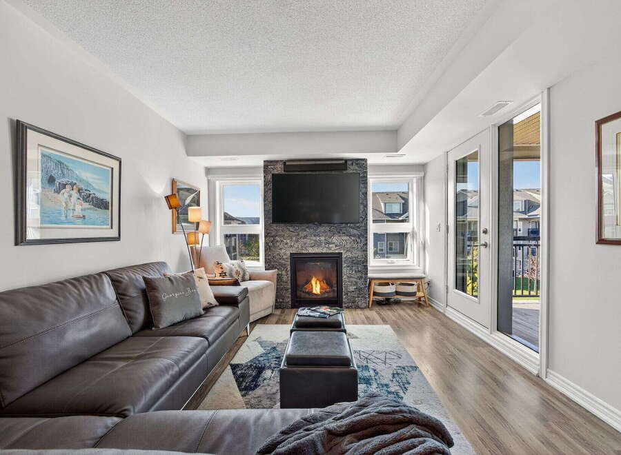 Step into luxury with this stunning living room! Featuring a cozy fireplace, a large TV, and a comfortable leather sofa, this space is perfect for relaxing or entertaining.
