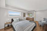 This stunning bedroom offers a serene retreat with its neutral color palette and ample natural light.
